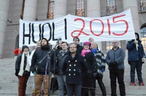 Erik Lydén Palefacen ja Pia Lohikosken välissä eduskuntatalon rappusilla Huoli 2015 kampanjan mielenilmauksessa.