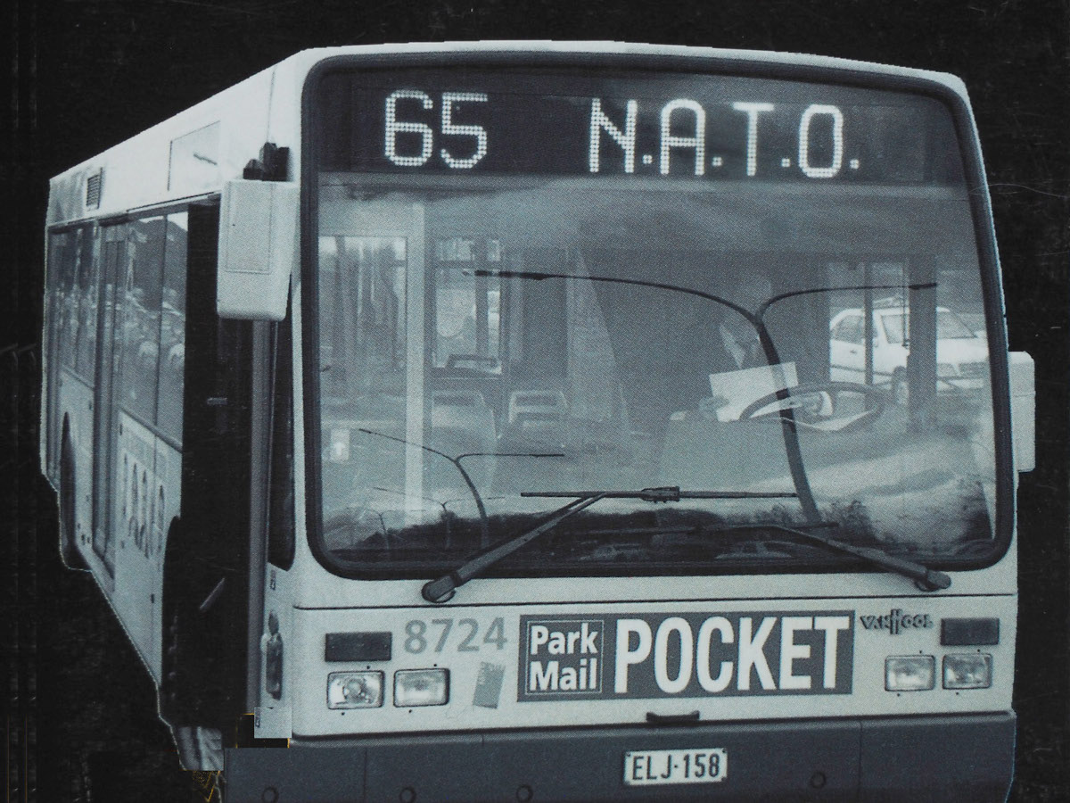 Mustavalkokuva bussista, jonka tuulilasin yläpuolella lukee Nato.