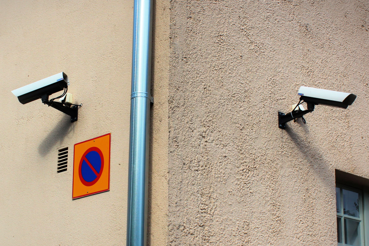 Kaksi seinään kiinnitettyä valvontakameraa.