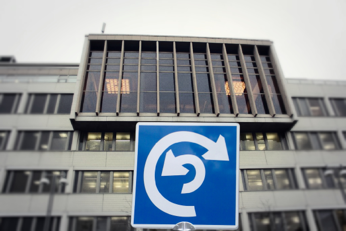 Tampereen virastotalon kuva, johon on lisätty kahteen suuntaan näyttävä liikennemerkki.