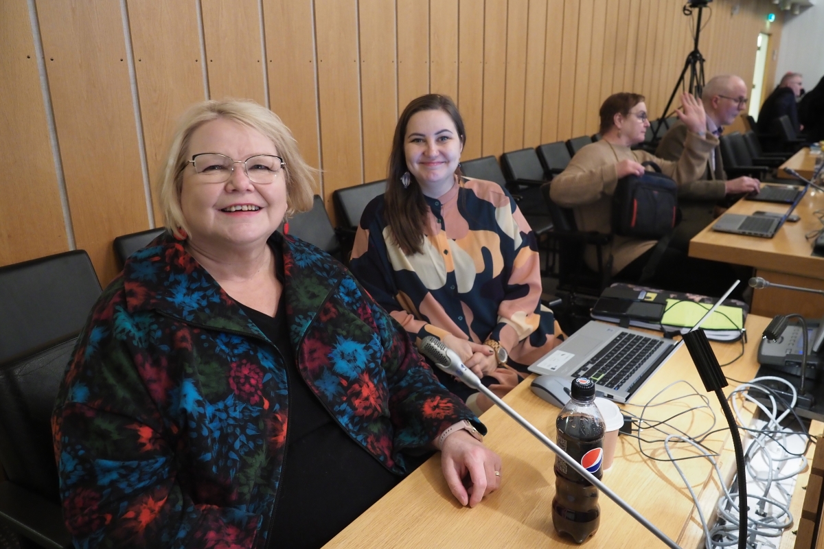 Kuvassa varavaltuutettu Sinikka Torkkola ja valtuutettu Minna Minkkinen istumassa vierekkäin pöydän ääressä valtuustosalissa.