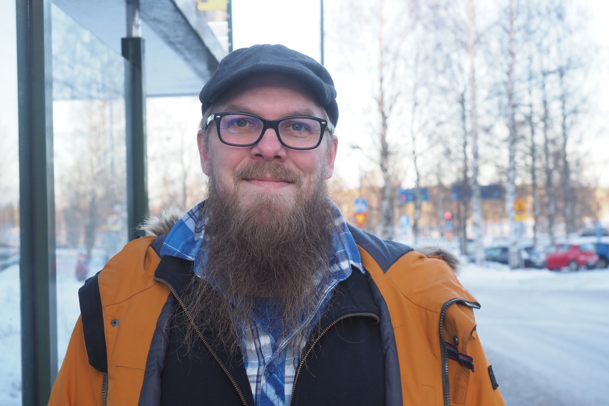 Aki Leppänen seisomassa bussipysäkillä talvella.