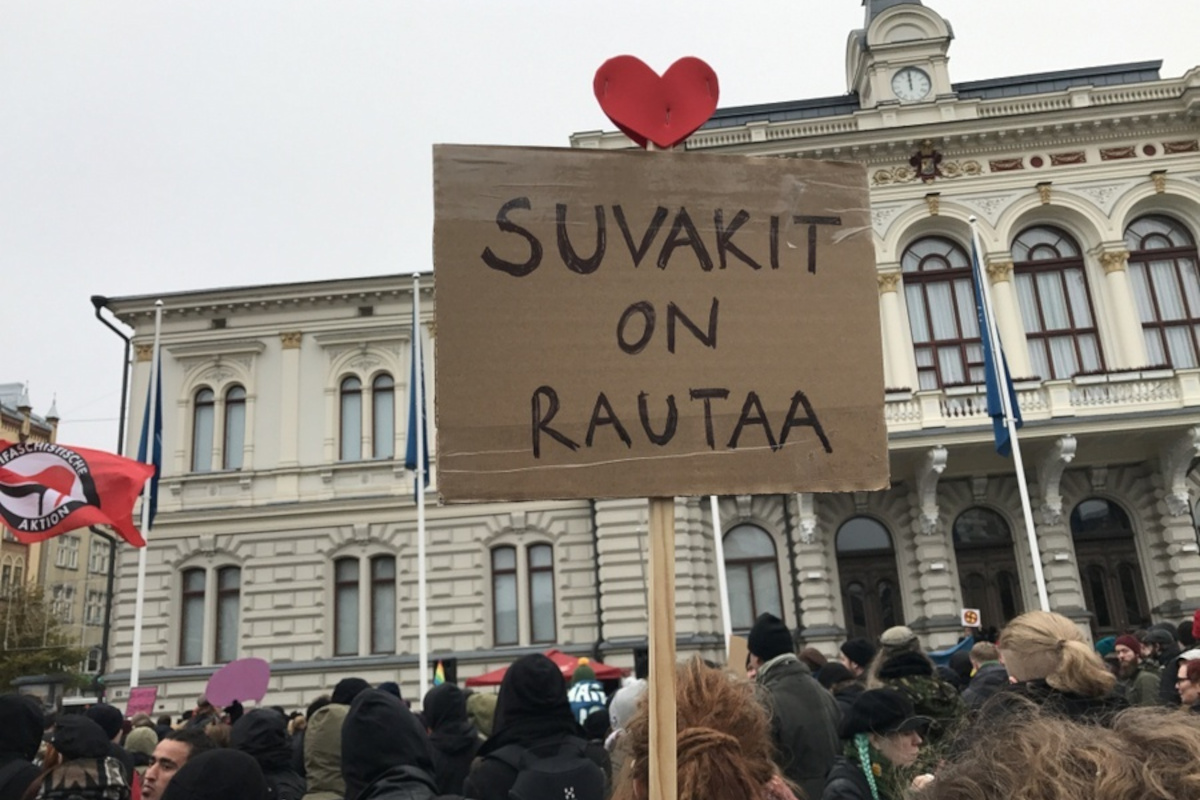 Mielenosoittajia Tampereen Keskustorilla. Kyltissä lulee suvakit on rautaa.