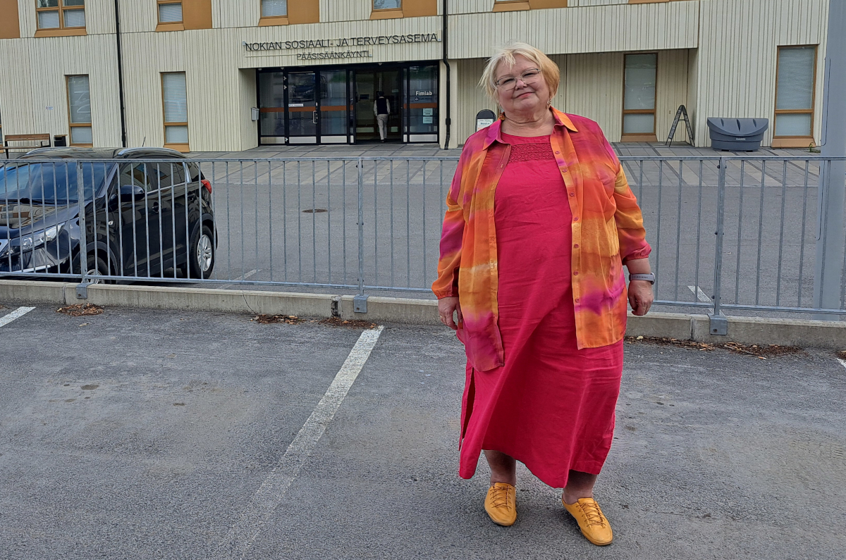 Sinikka Torkkola seisomassa Nolian sotekeskuksen edessä.